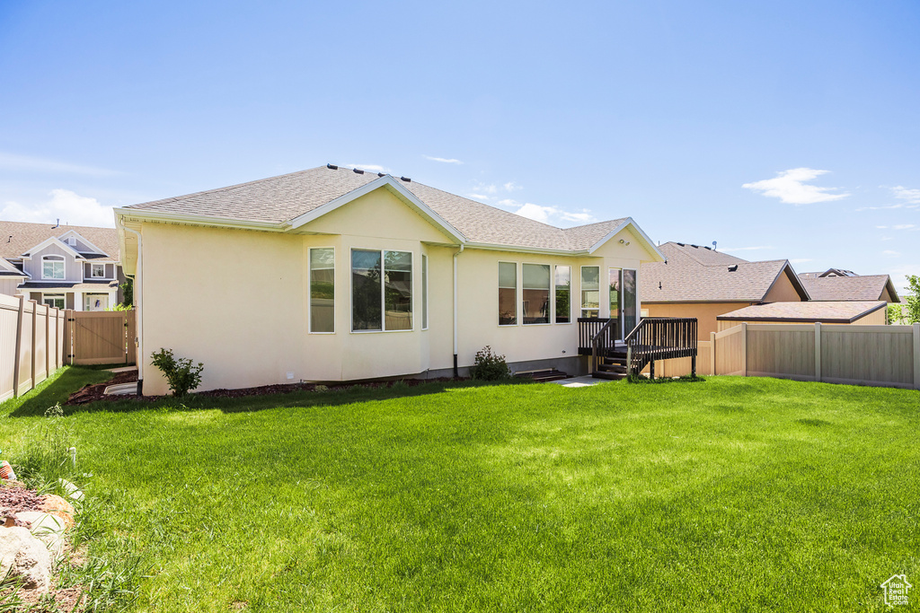 Back of property featuring stucco siding and a shingled roof