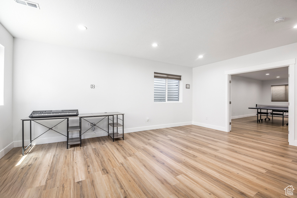Unfurnished room with light wood-type flooring, a smoke detector, baseboards, and recessed lighting
