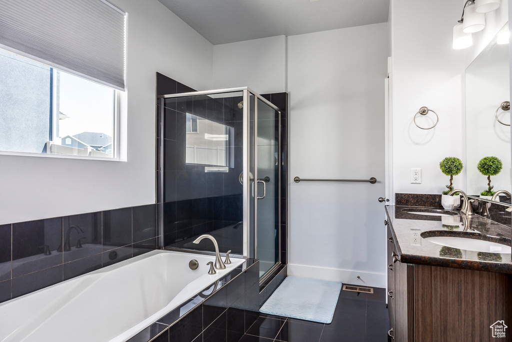 Full bath featuring tile patterned flooring, a shower stall, a garden tub, and double vanity
