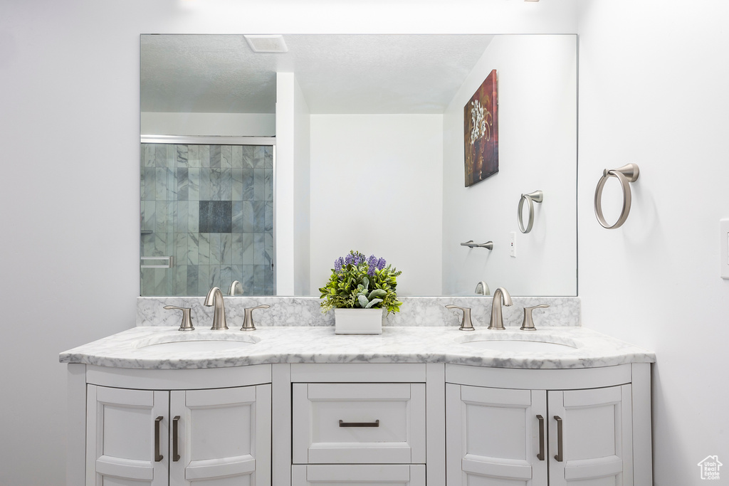 Full bathroom with tiled shower and double vanity