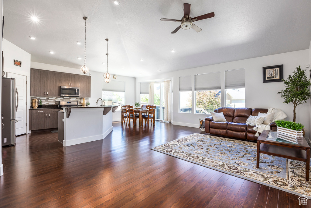 Living room with a ceiling fan, dark wood-style flooring, recessed lighting, and baseboards
