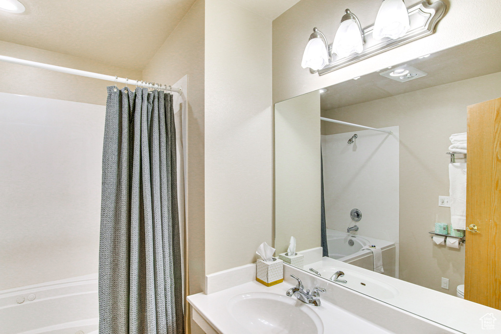 Bathroom with vanity and shower / bath combo with shower curtain