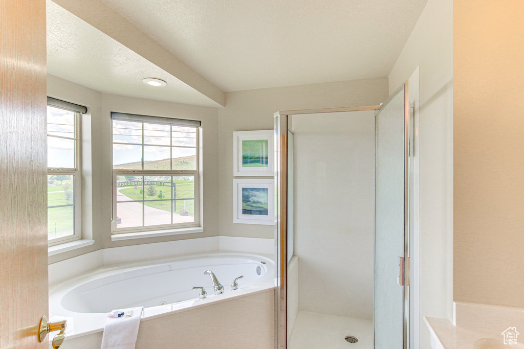 Full bath featuring a garden tub and a shower stall