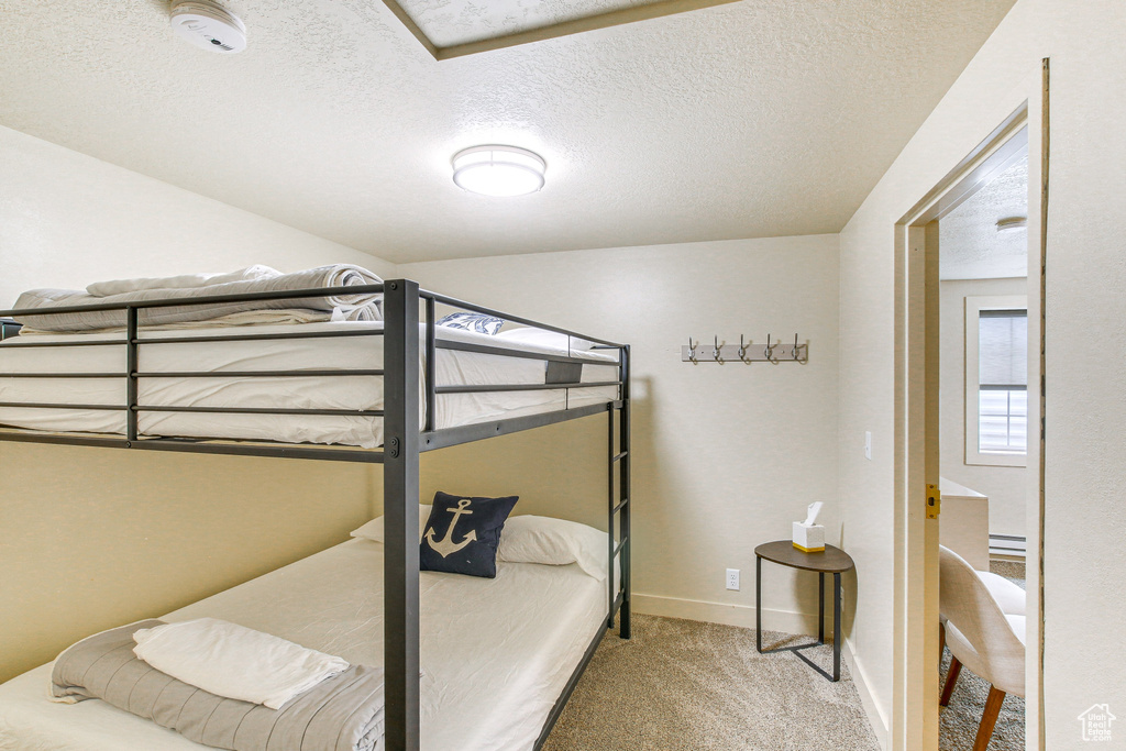 Bedroom with baseboards, a textured ceiling, and carpet floors