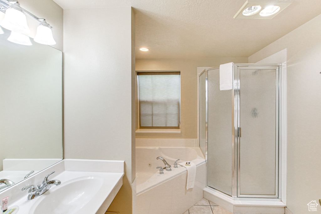 Bathroom with a sink, tile patterned flooring, a stall shower, and a garden tub
