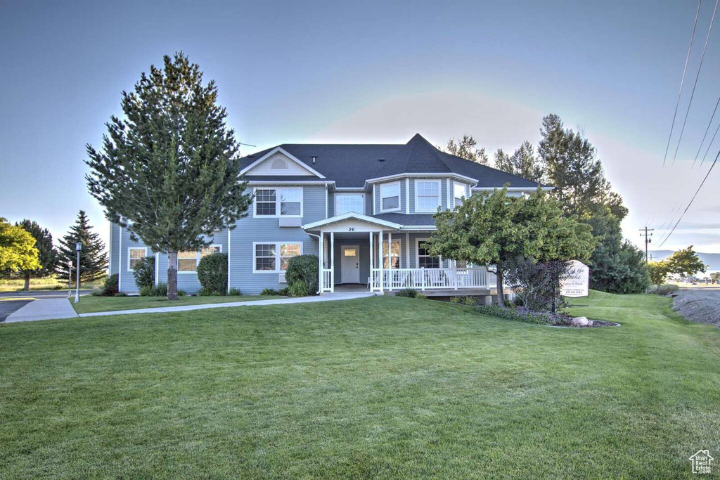 Victorian-style house with a front lawn and a porch