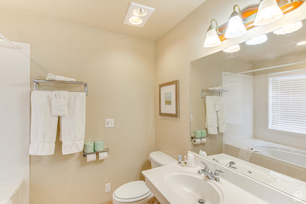 Full bath with toilet, vanity, a shower, and a tub