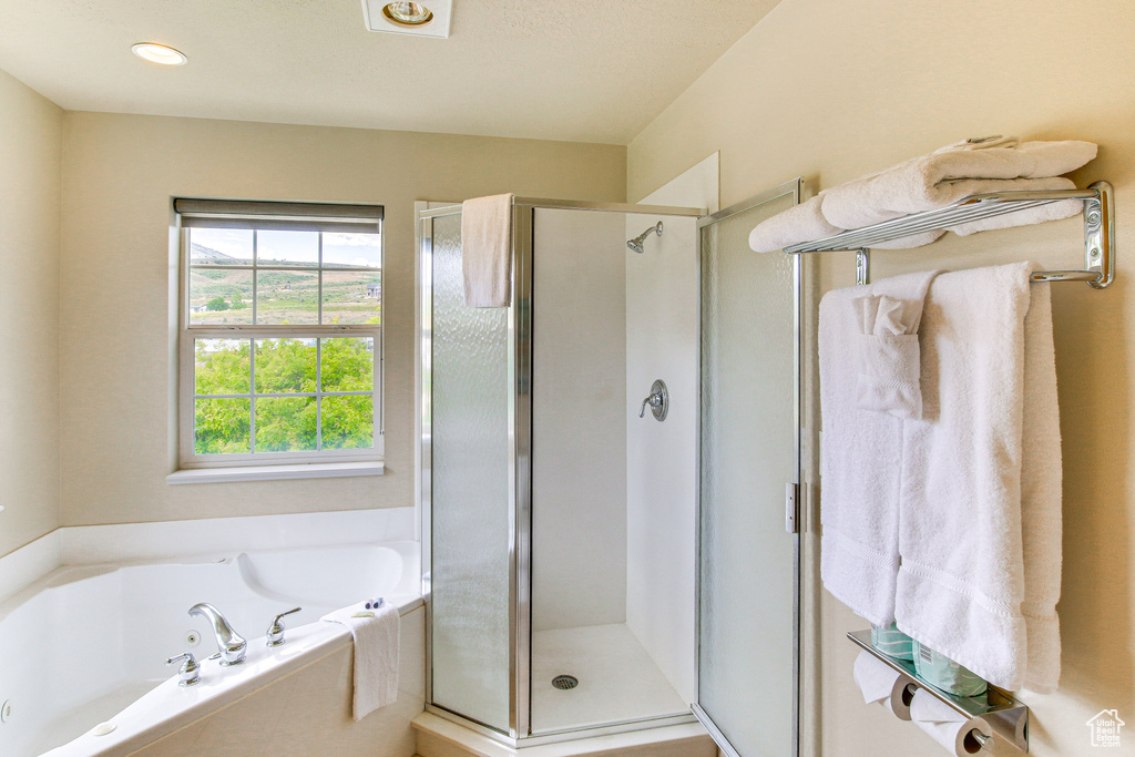Full bathroom featuring a shower stall and a garden tub