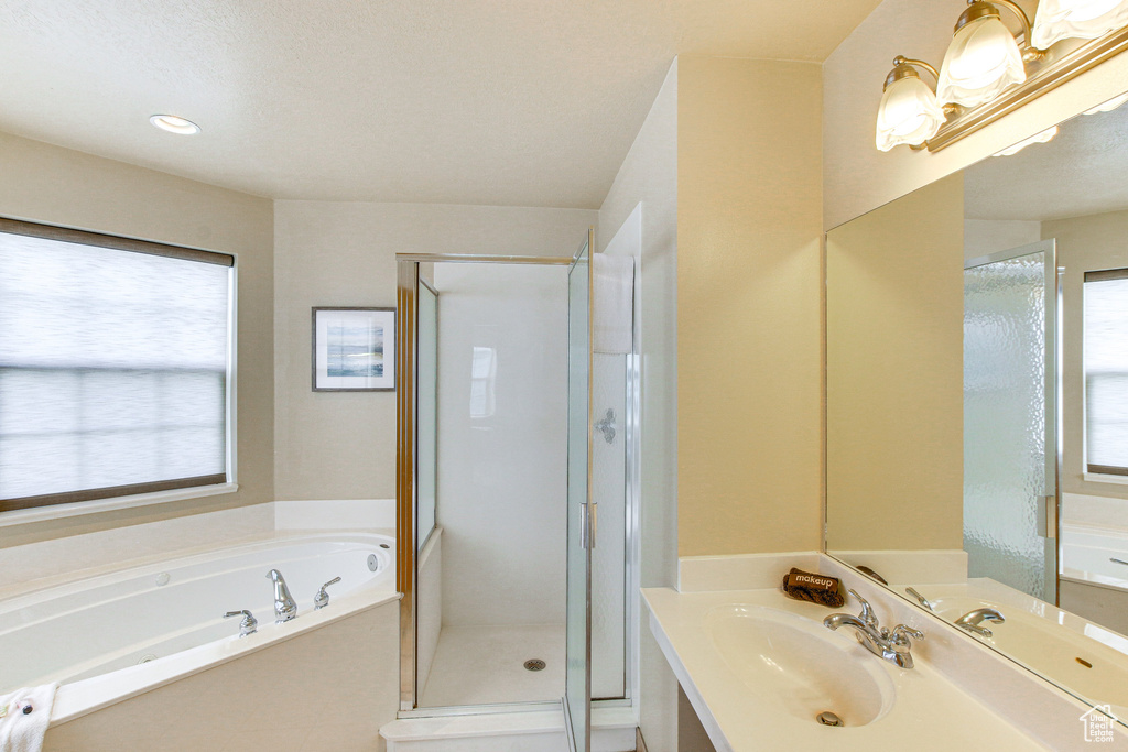 Bathroom with a garden tub, vanity, and a shower stall