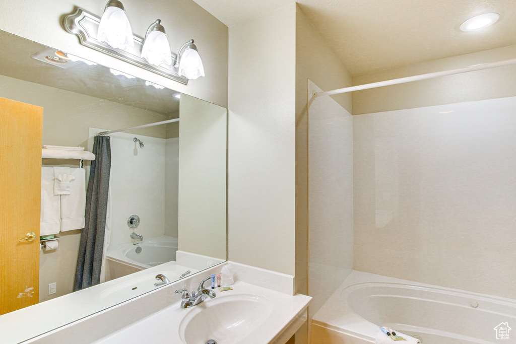 Full bathroom featuring shower / bath combo with shower curtain, vanity, and recessed lighting