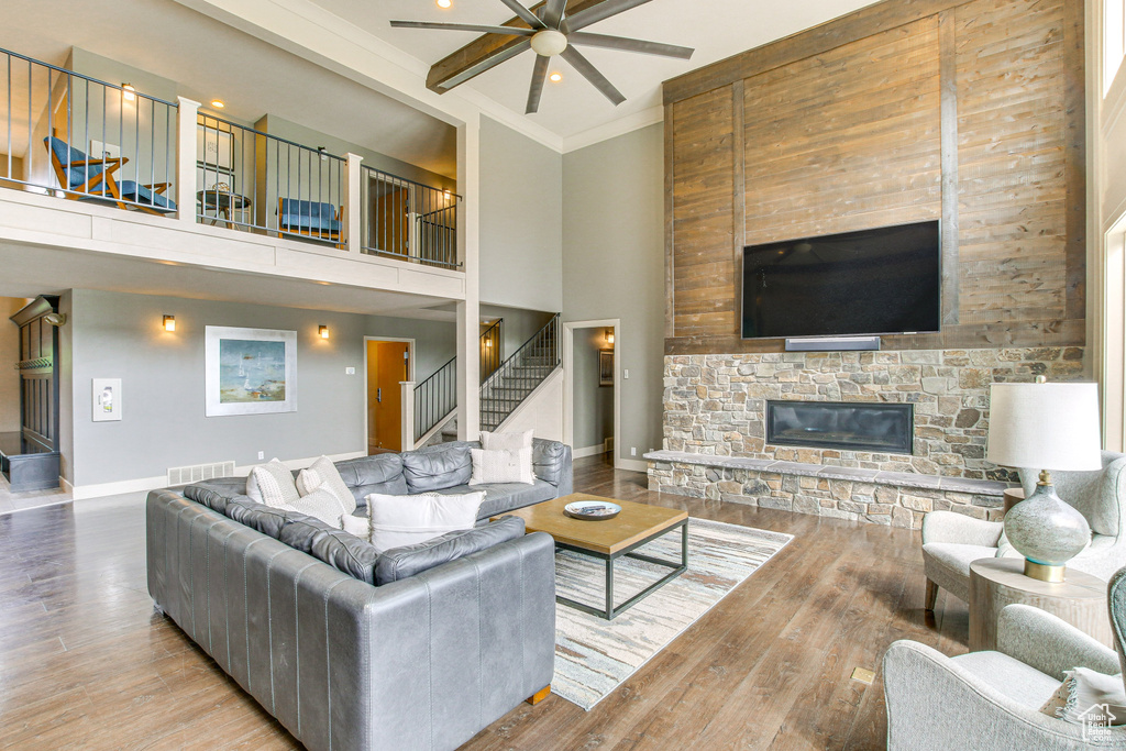 Living room with visible vents, wood finished floors, ceiling fan, and stairs