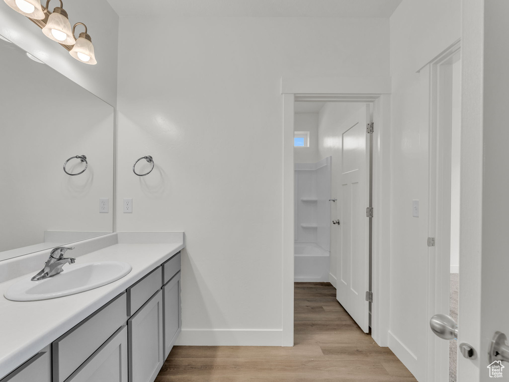 Bathroom featuring wood finished floors, vanity, and baseboards