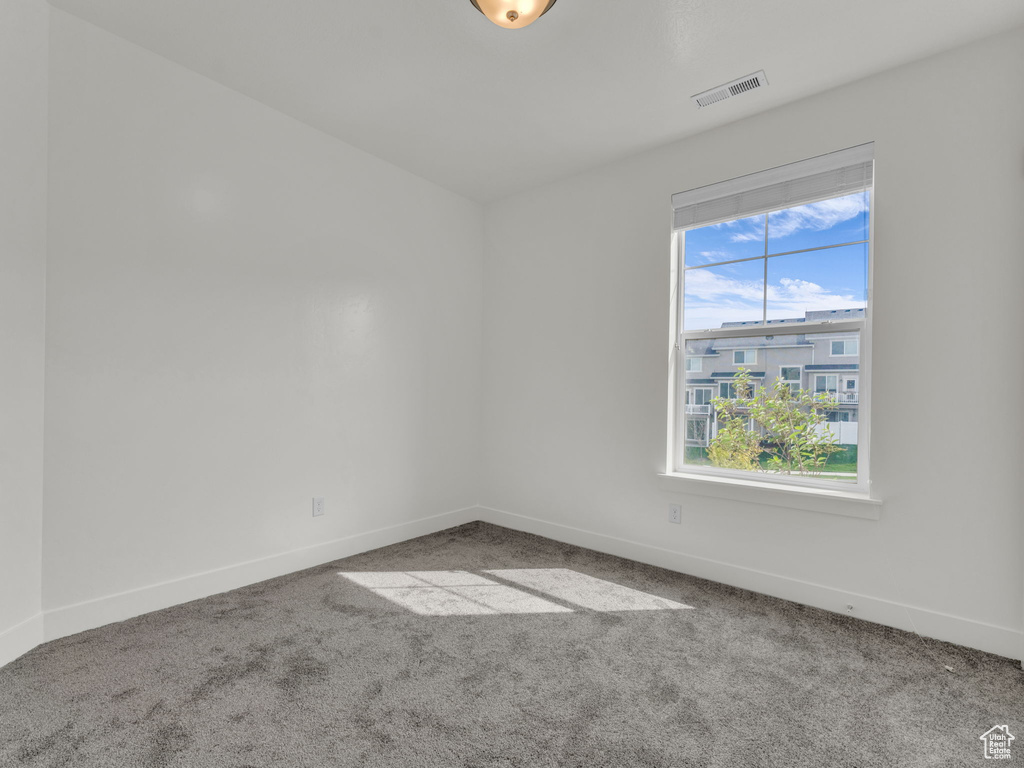 Carpeted spare room with baseboards