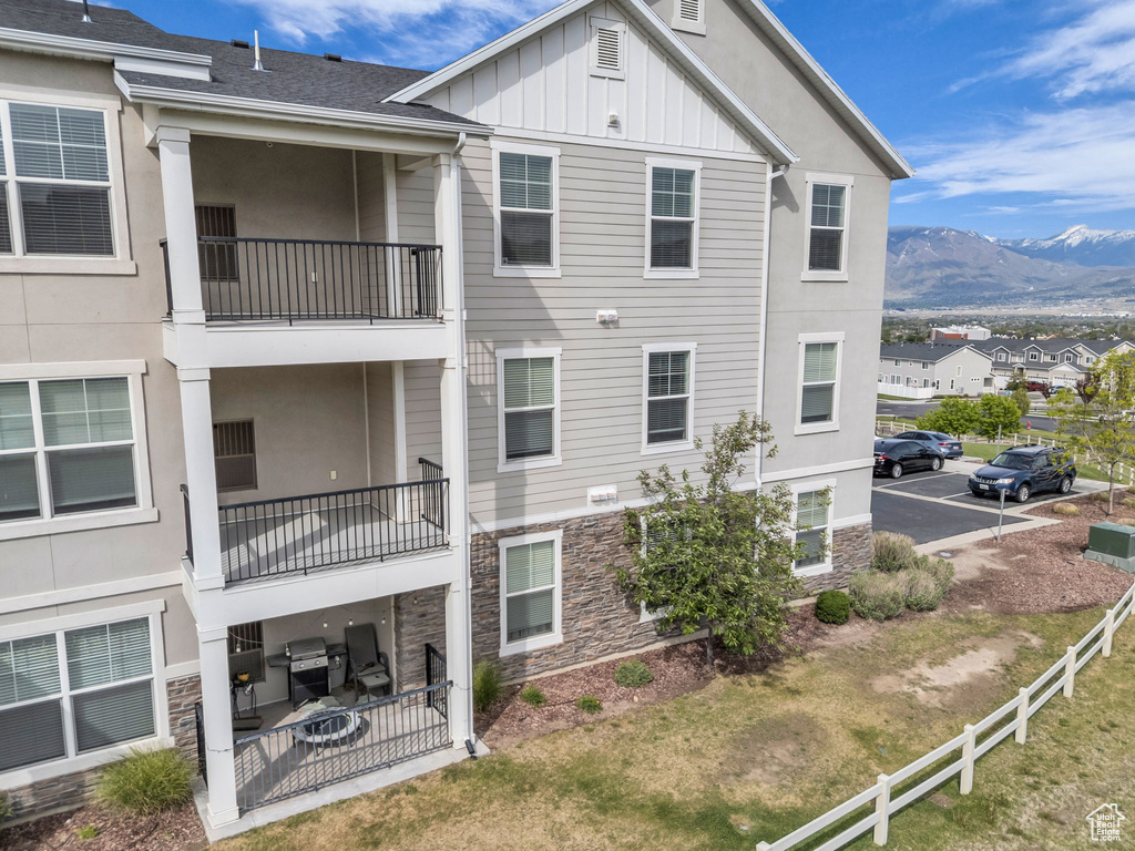 View of property featuring a mountain view, fence, and uncovered parking
