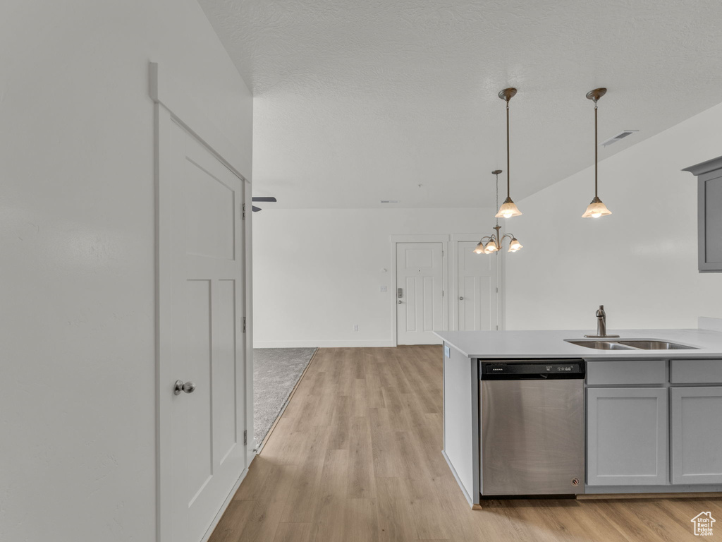Kitchen featuring a sink, dishwasher, gray cabinets, and light wood-style flooring