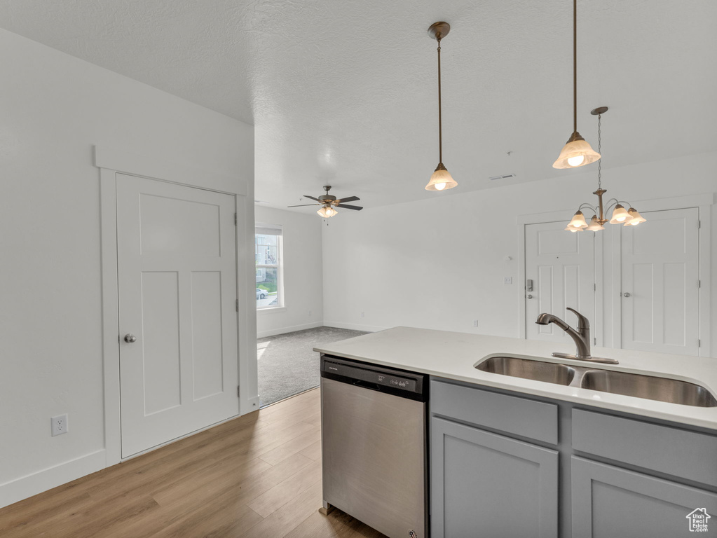 Kitchen with dishwasher, a sink, gray cabinets, and baseboards