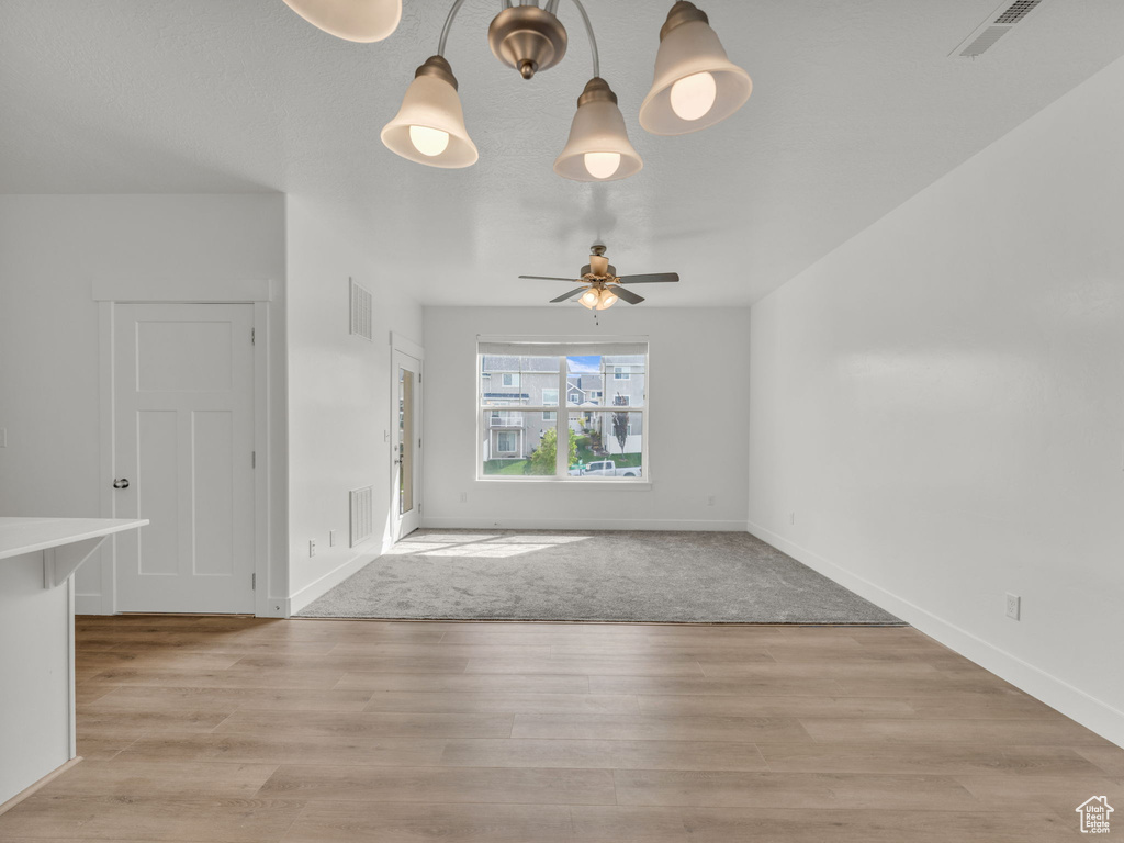 Unfurnished living room with light wood finished floors, ceiling fan, and baseboards