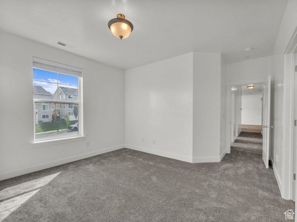 Carpeted empty room with baseboards