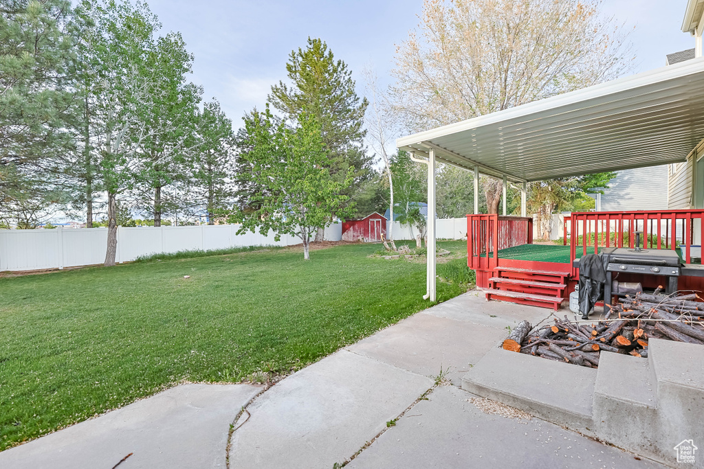 View of yard featuring a wooden deck, an outdoor structure, and a storage unit