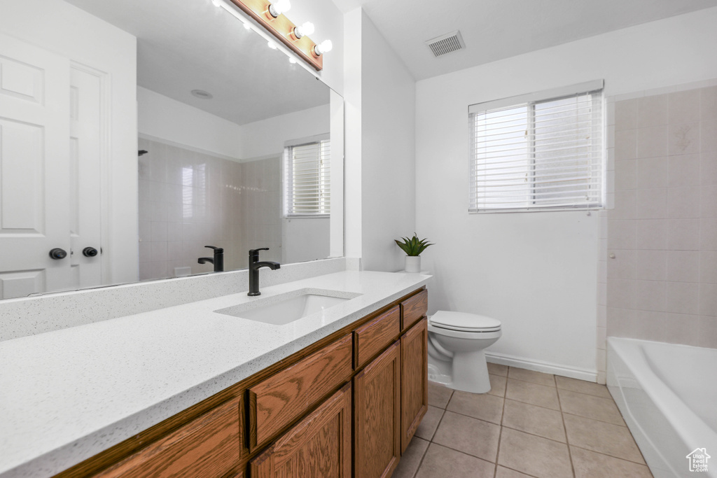 Bathroom featuring tile patterned flooring, toilet, and vanity