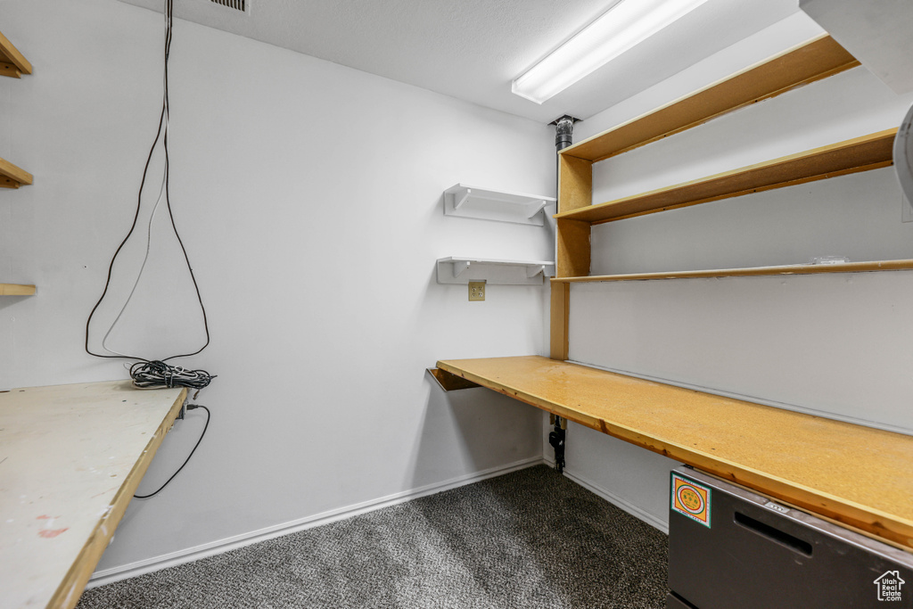 Unfurnished office featuring dark carpet and baseboards