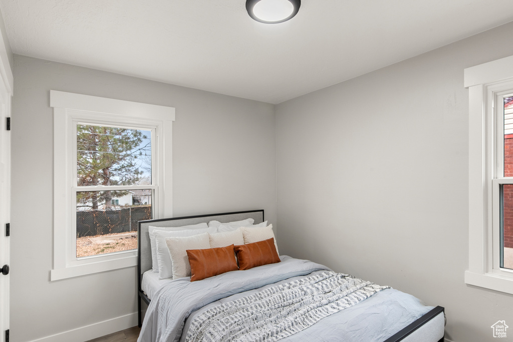 Bedroom featuring multiple windows, wood finished floors, and baseboards