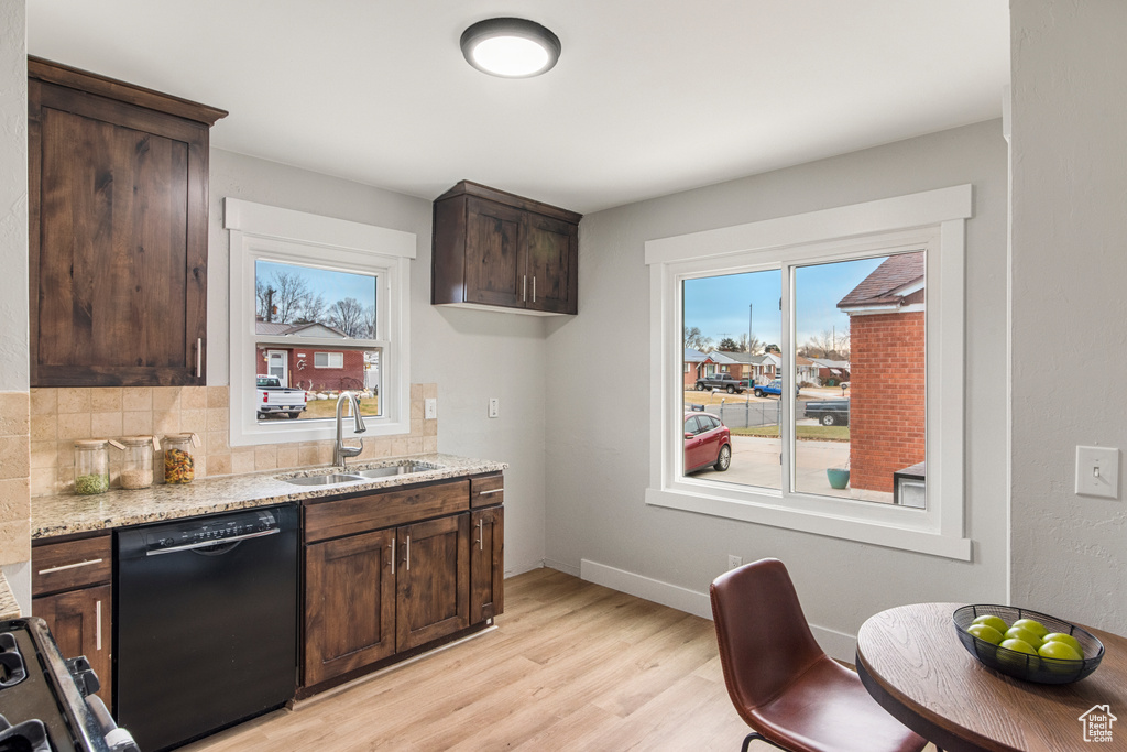 Kitchen with black dishwasher, plenty of natural light, a sink, and dark brown cabinets