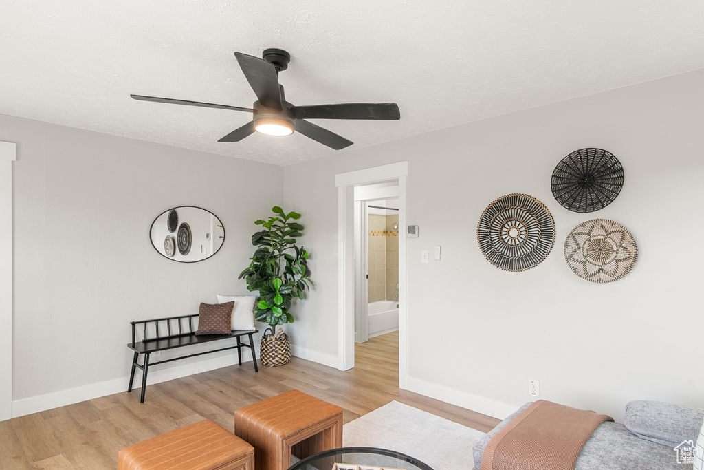 Living room with light wood-style floors, ceiling fan, and baseboards