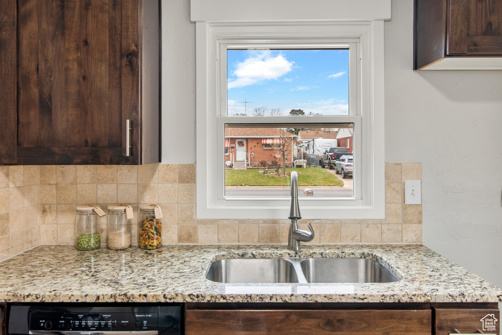 Kitchen with a sink, dark brown cabinetry, dishwasher, and tasteful backsplash
