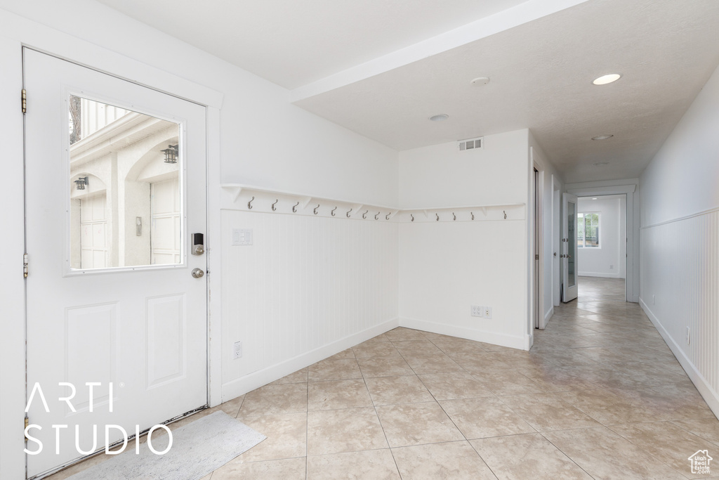 Interior space featuring light tile patterned floors, visible vents, baseboards, and recessed lighting