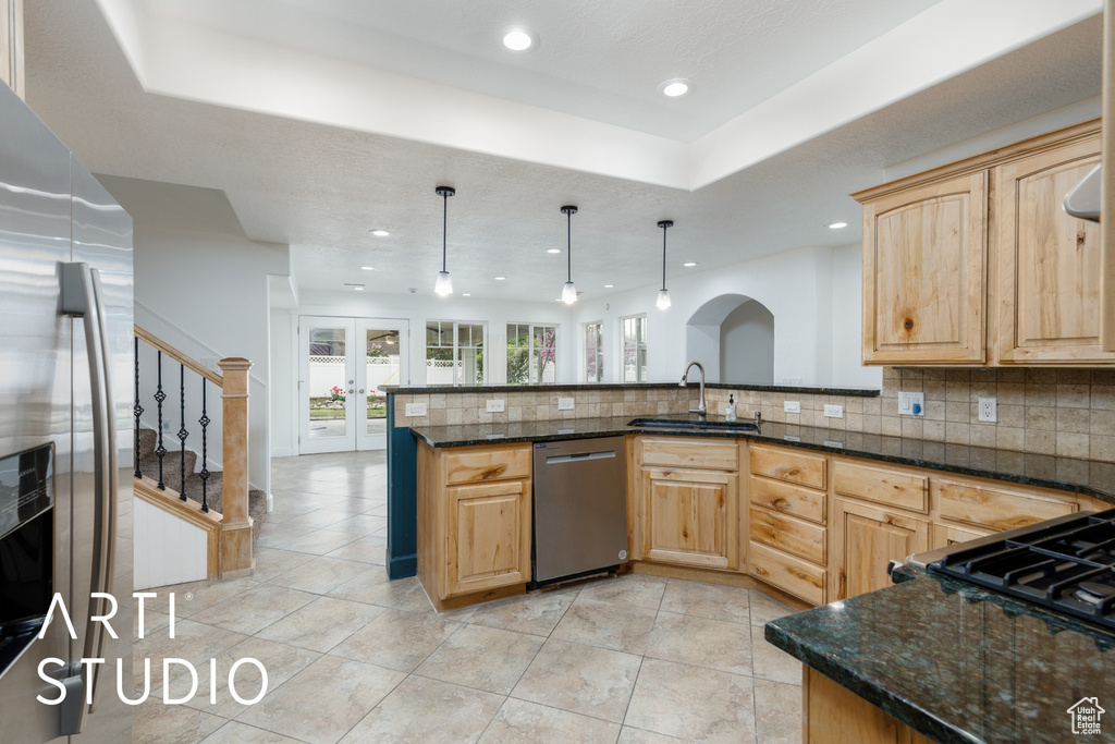 Kitchen with recessed lighting, stainless steel appliances, light brown cabinetry, and a sink