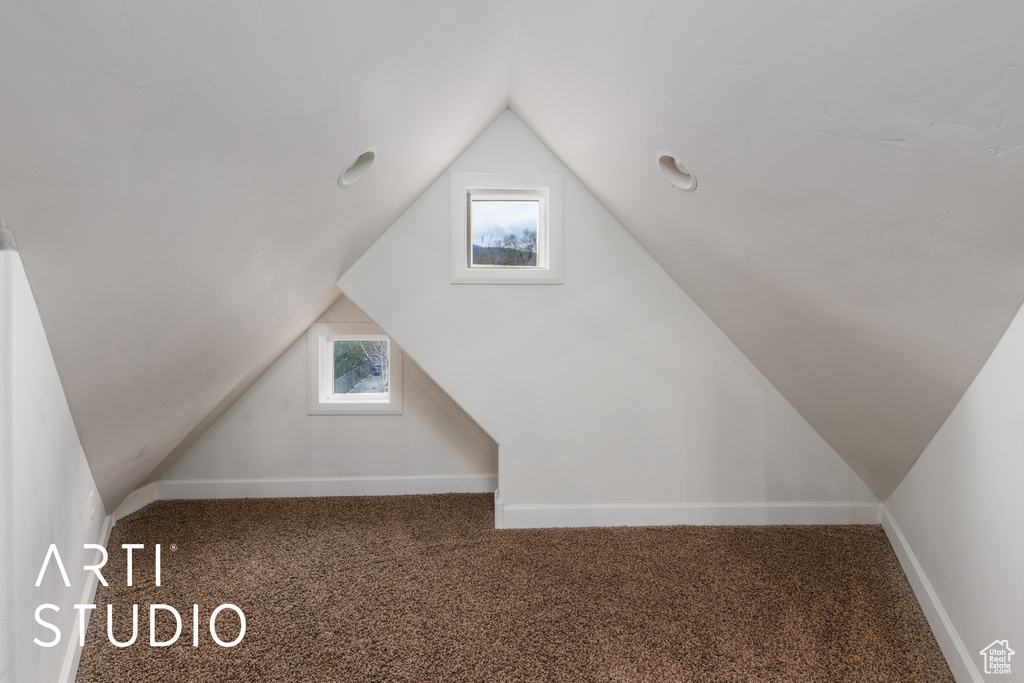 Additional living space featuring lofted ceiling, baseboards, and carpet