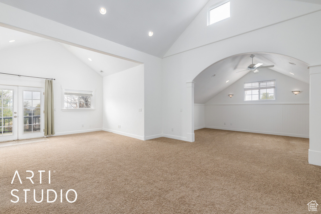 Additional living space with carpet flooring, ceiling fan, and arched walkways