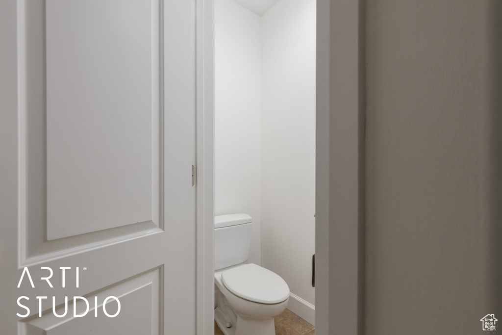 Bathroom with tile patterned floors, toilet, and baseboards