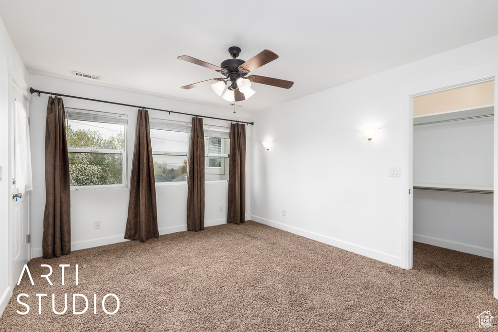 Unfurnished bedroom featuring baseboards, a ceiling fan, visible vents, and carpet