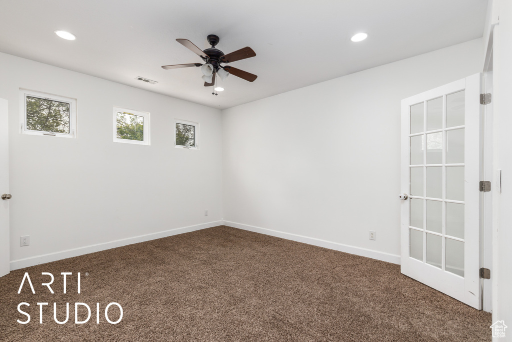 Carpeted spare room with a ceiling fan, visible vents, and recessed lighting