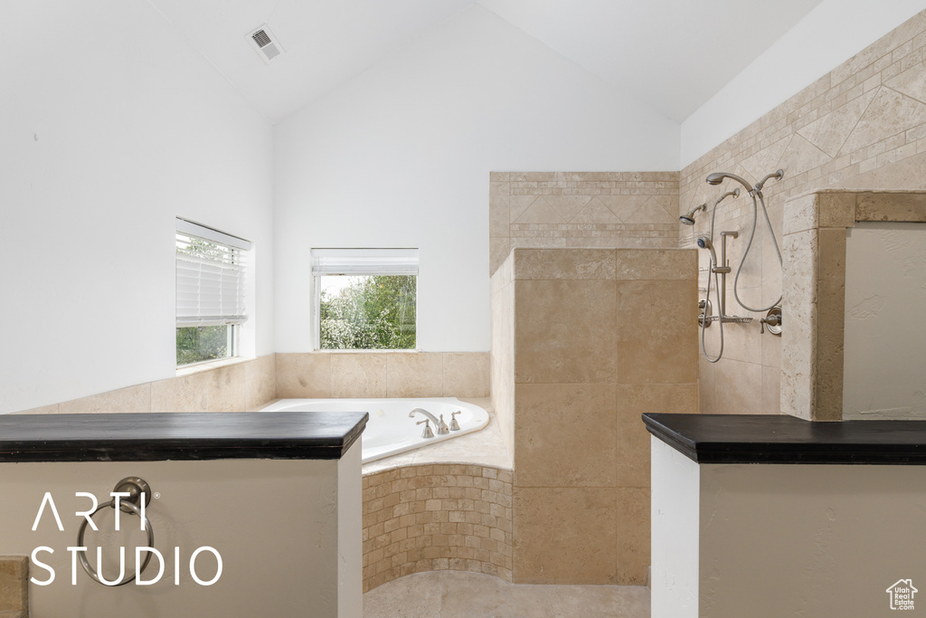 Full bath with walk in shower, a garden tub, visible vents, and vaulted ceiling