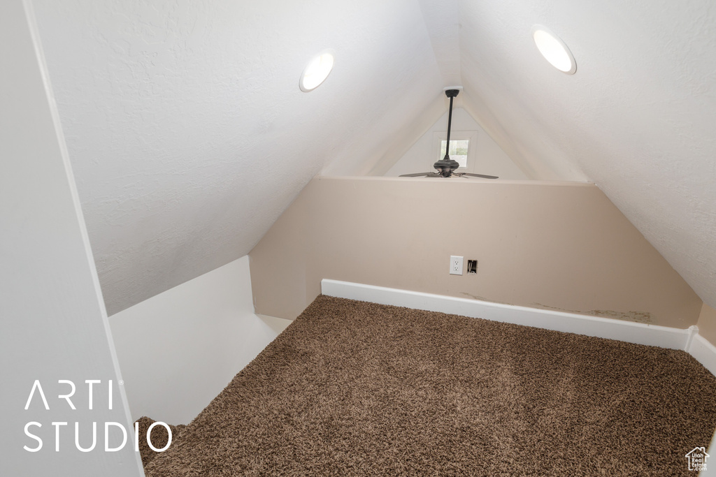 Additional living space with lofted ceiling, carpet floors, and a ceiling fan