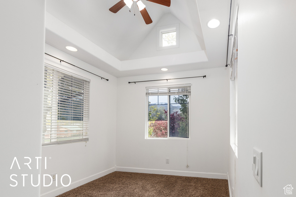 Spare room with a wealth of natural light, baseboards, ceiling fan, and carpet floors