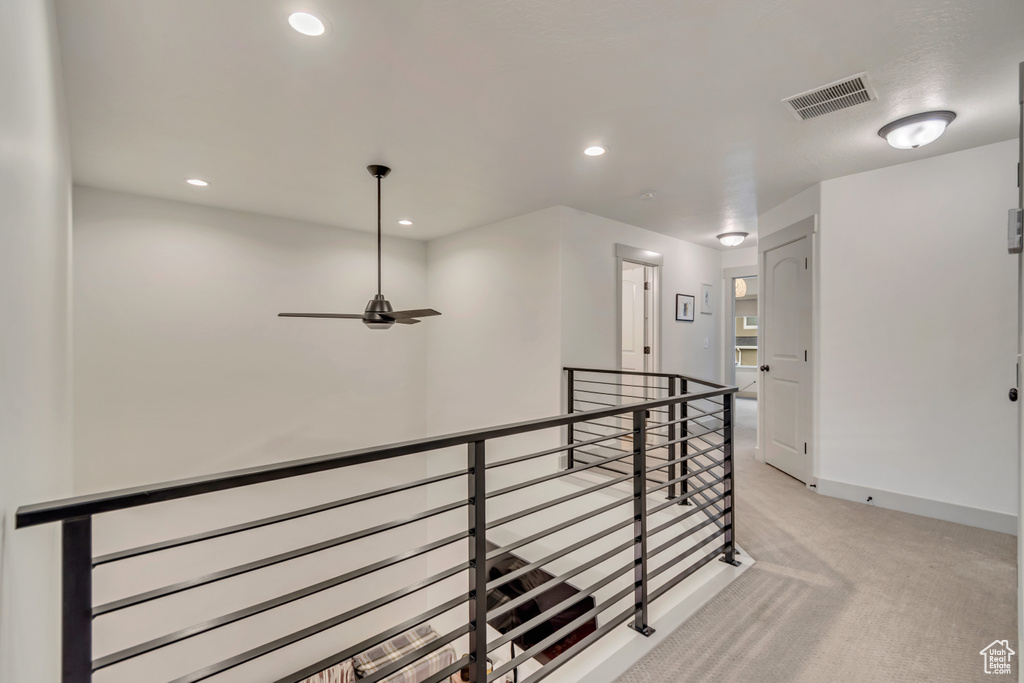 Hallway featuring recessed lighting, an upstairs landing, visible vents, and light colored carpet