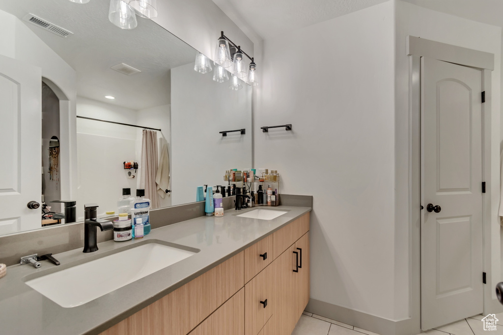 Full bath featuring tile patterned flooring, visible vents, a sink, and double vanity