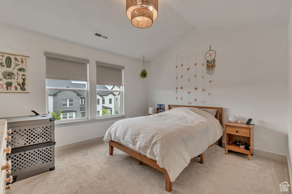 Bedroom featuring vaulted ceiling, carpet floors, baseboards, and visible vents