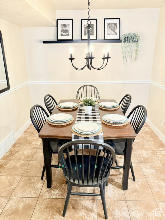 Dining room with a chandelier and tile patterned floors