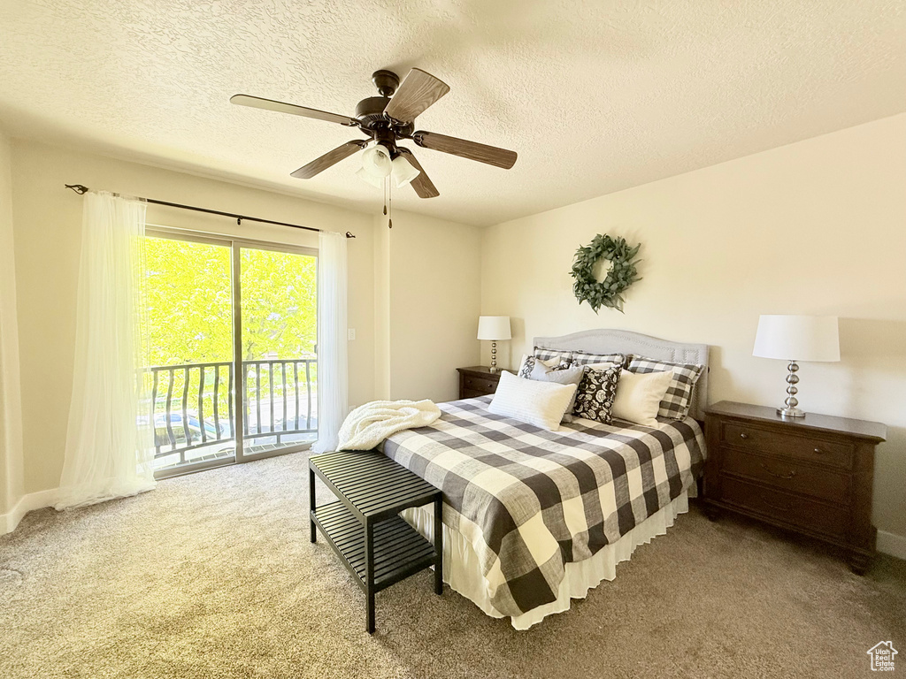 Carpeted bedroom featuring access to exterior, a textured ceiling, and a ceiling fan