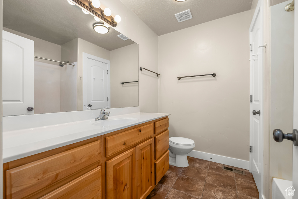 Full bath with baseboards, toilet, and vanity