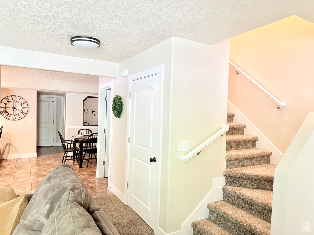 Staircase featuring tile patterned flooring and a textured ceiling