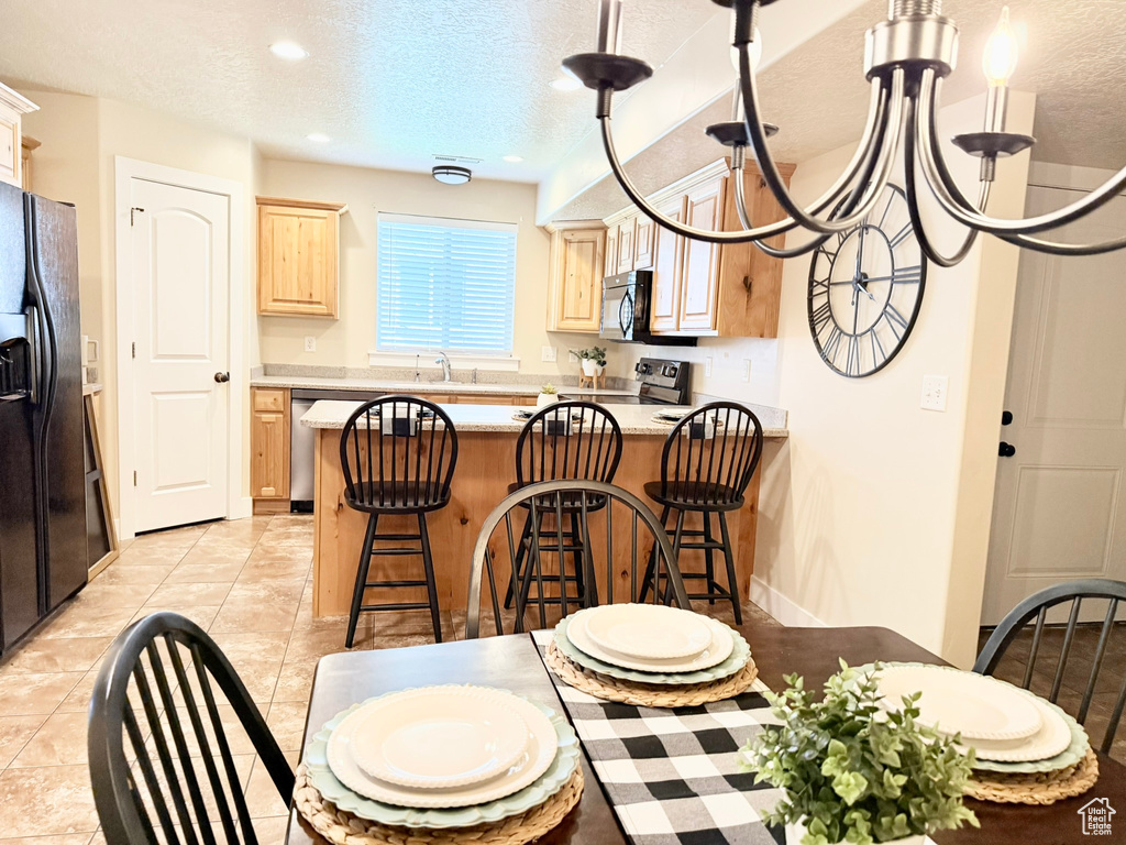 Dining room featuring a textured ceiling, recessed lighting, and light tile patterned flooring