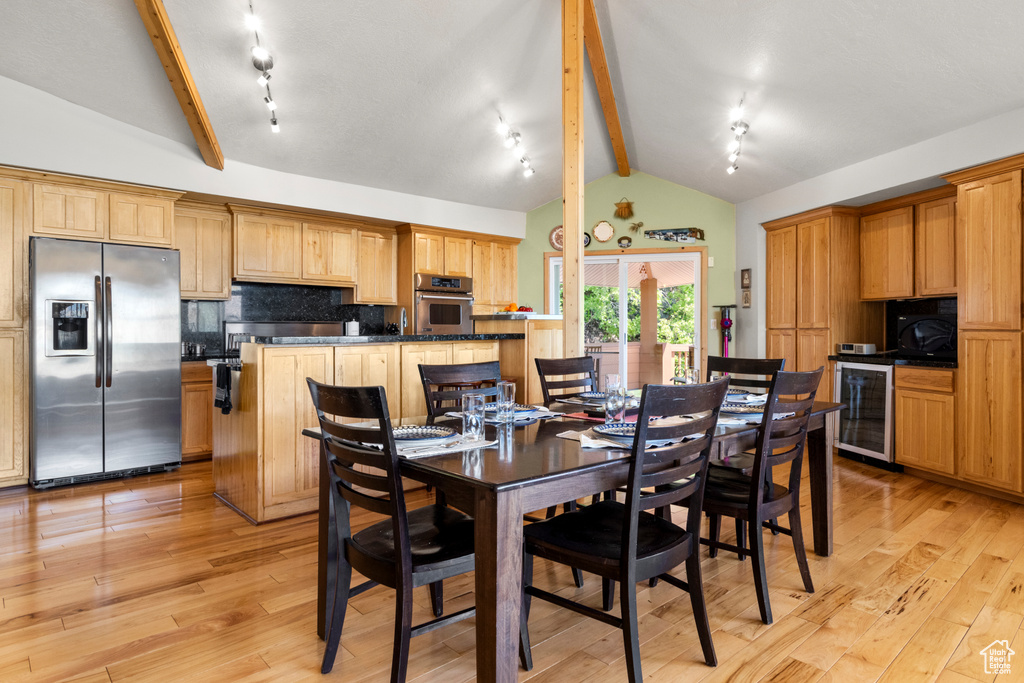 Dining space with wine cooler and light wood-style flooring