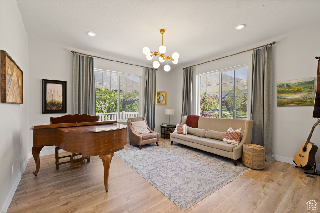 Sitting room with an inviting chandelier, recessed lighting, light wood-style flooring, and baseboards