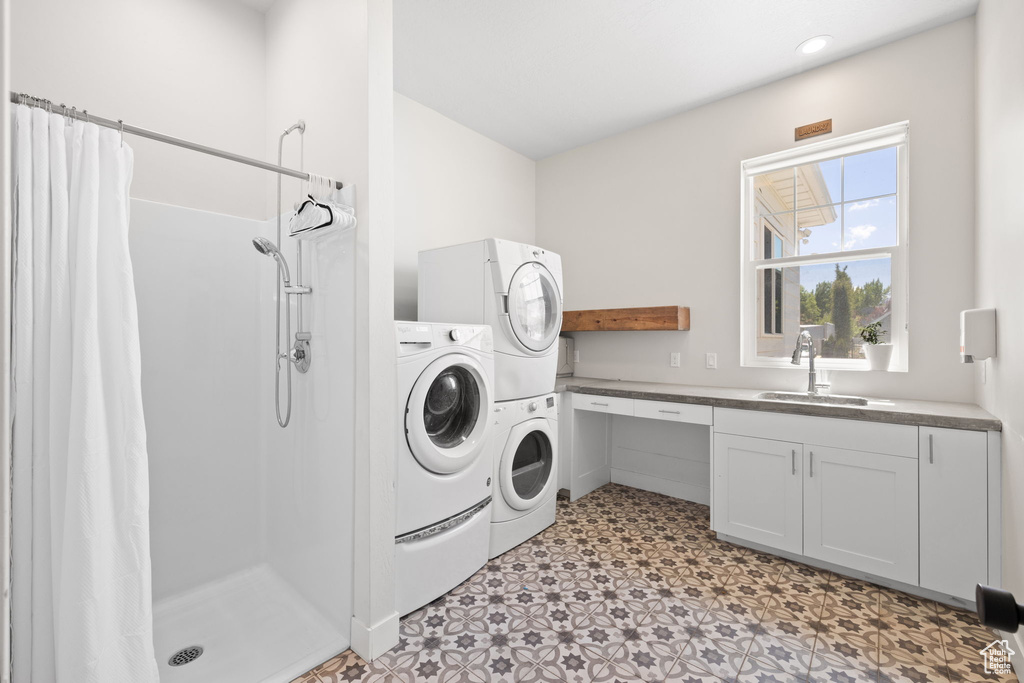 Washroom featuring a sink, light floors, laundry area, and independent washer and dryer